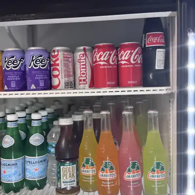 A drinks cooler stocked with sodas, Mexican Coke and Jarritos